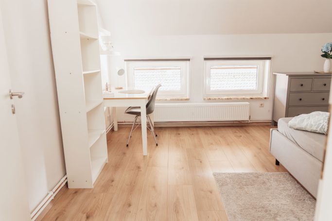 Schlafzimmer mit Arbeitspaltz Helles Schlafzimmer mit Arbeitsplatzt und Fenster mit Rollos